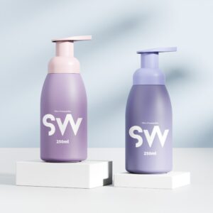 Two 250ml HDPE foam bottles with pink and lavender pumps are displayed on white platforms against a soft blue background.
