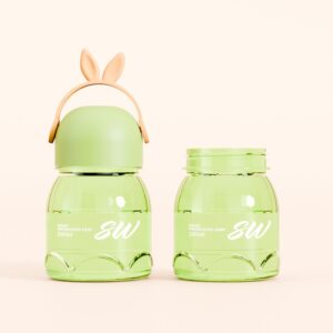 Two 250ml green plastic bottles labeled "SW"; one has a bunny-ear cap and handle, set against a light beige background.