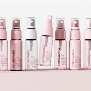 Seven spray bottles—six pink, one clear—labeled "SOMEWANG," on a pink surface.
