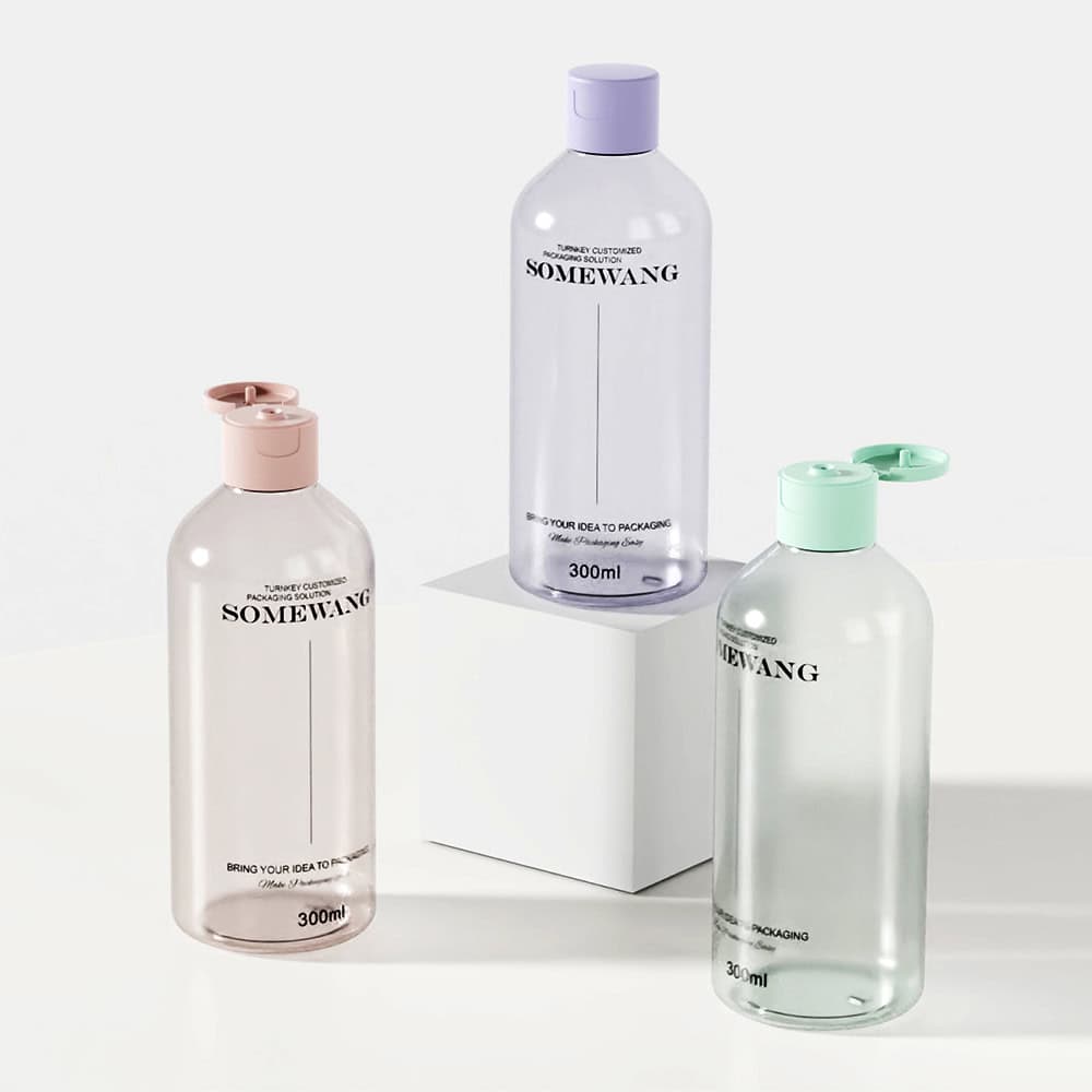 Three 300ml PET round bottles with purple, green, and brown caps are on white surface; one is on a small pedestal.